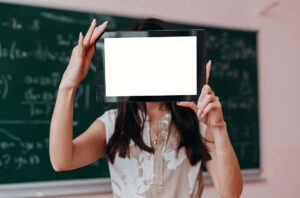 WordPress Schulungen 2 WordPress Schulung: Eine Frau vor einer Tafel hält ein Tablet hoch